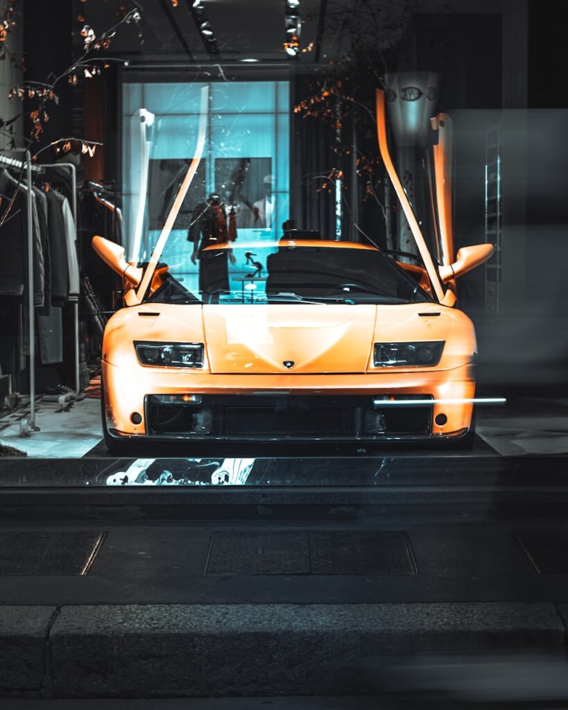 an orange sports car parked in front of a building