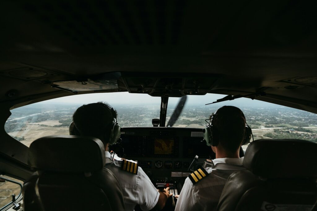 a couple of pilots sitting in the cockpit of a plane