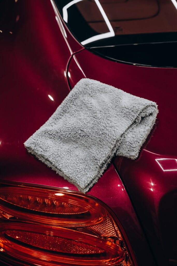 Gray microfiber cloth resting on a red car