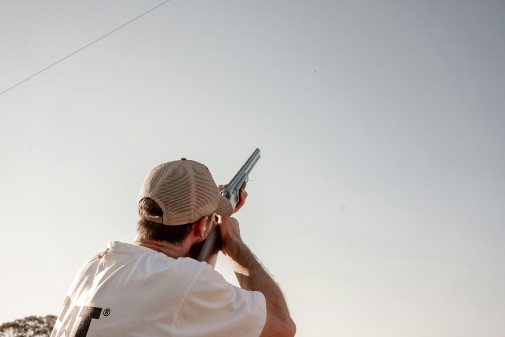 man pointing gun on sky