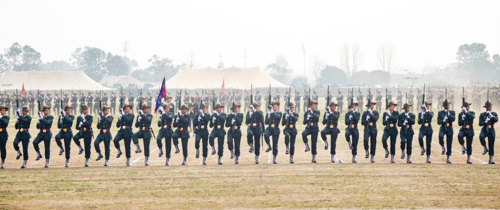 Soldiers march in formation on a field.
