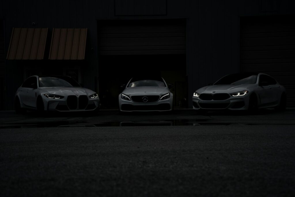 Three cars parked in front of a building at night