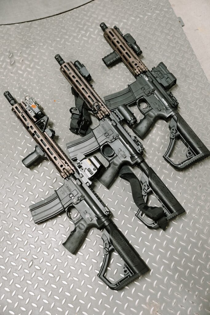Three assault rifles sit side by side.