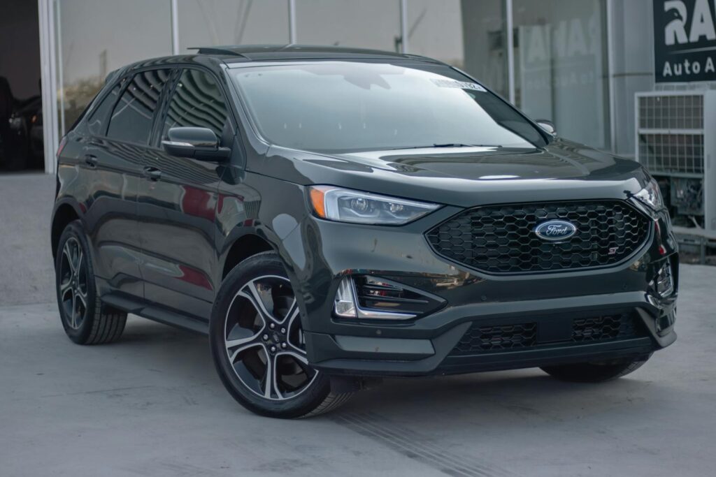 A shiny black Ford SUV parked in an auto showroom, showcasing modern design and style.