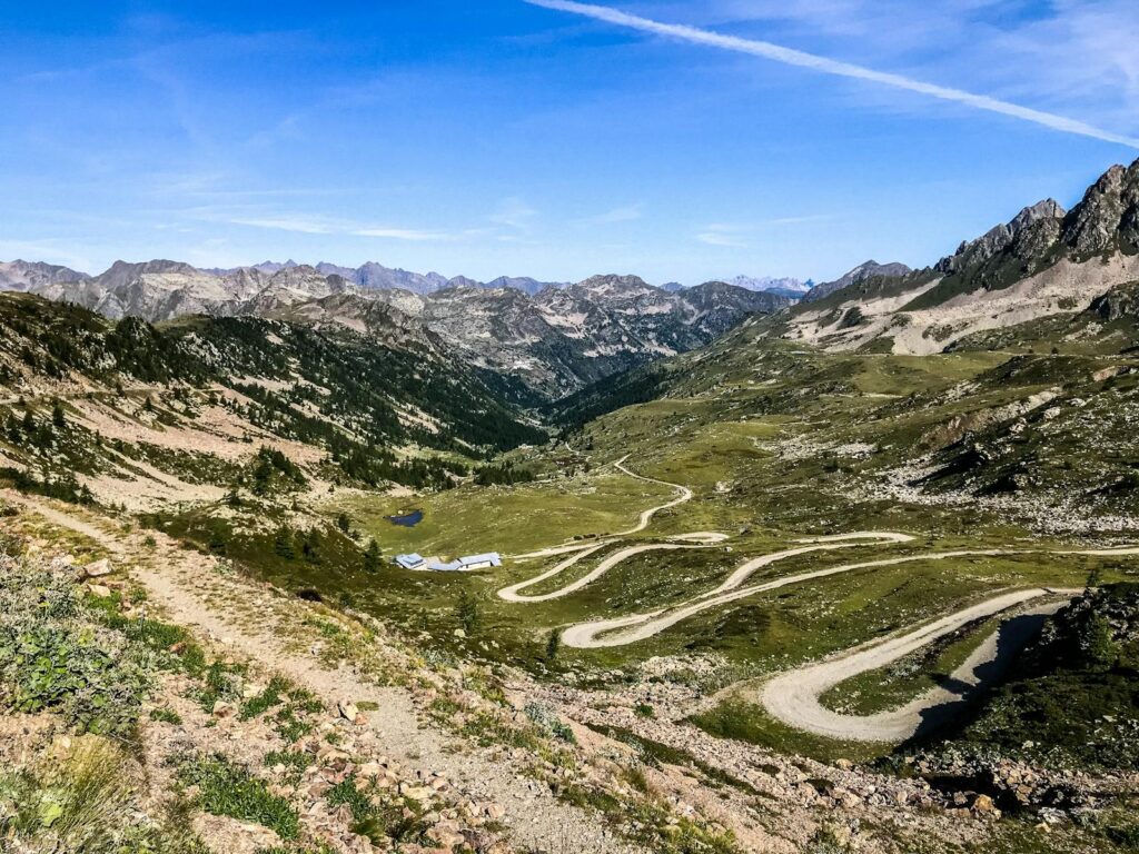 Explore a winding mountain road surrounded by breathtaking summer scenery.