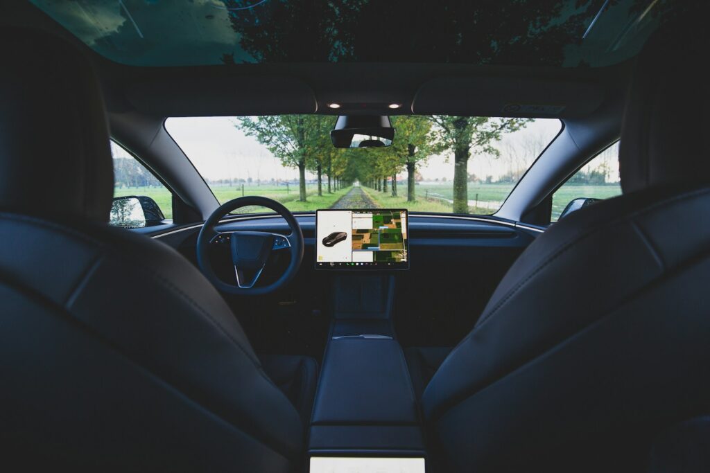 the interior of a car with a laptop on the dashboard