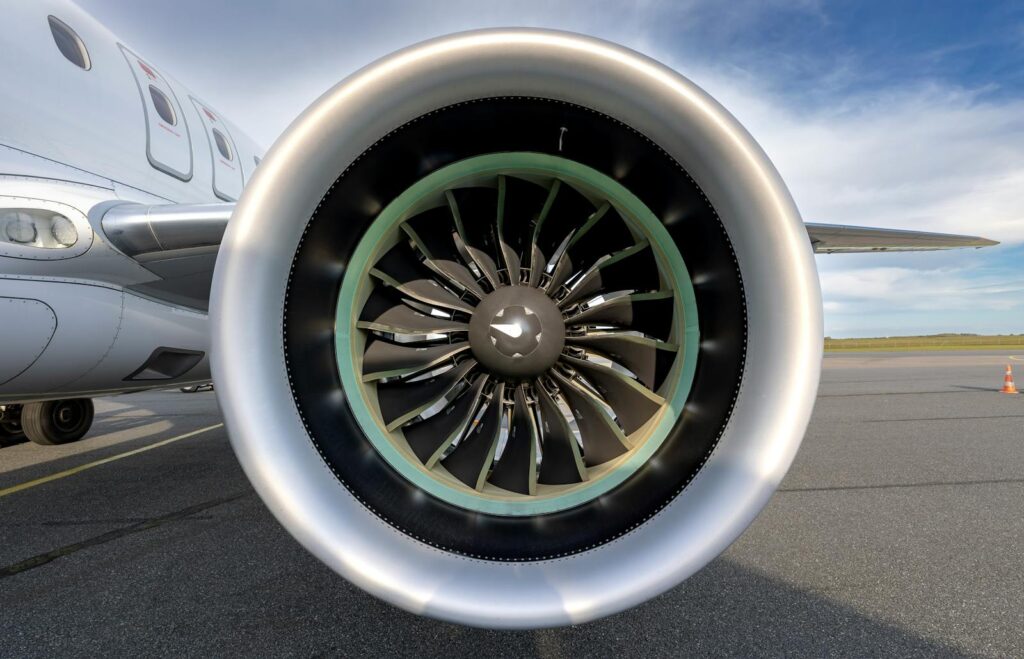 Detailed view of an aircraft jet engine on a sunny day at Sylt airport runway.