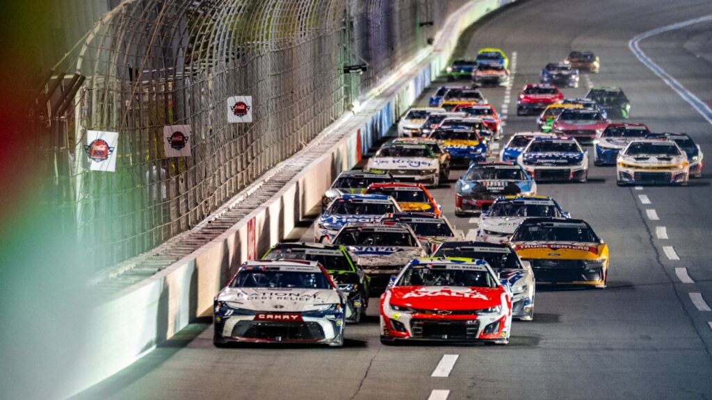 Race cars speed around a track.