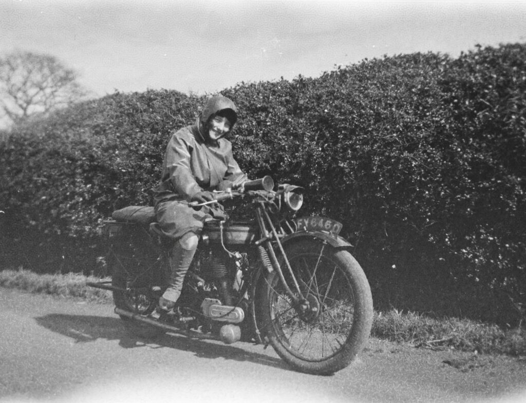 a man riding on the back of a motorcycle down a road