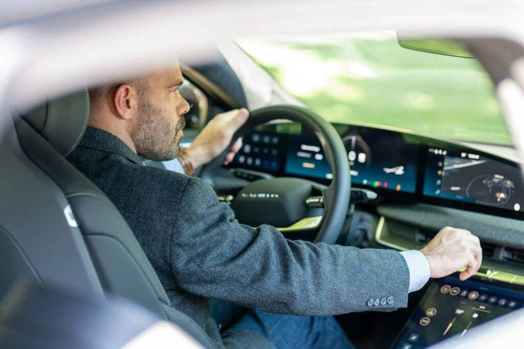 a man in a suit driving a car