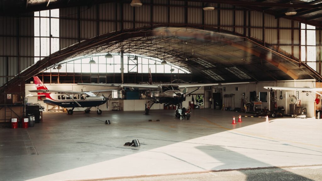 Airplanes are inside a spacious hangar.