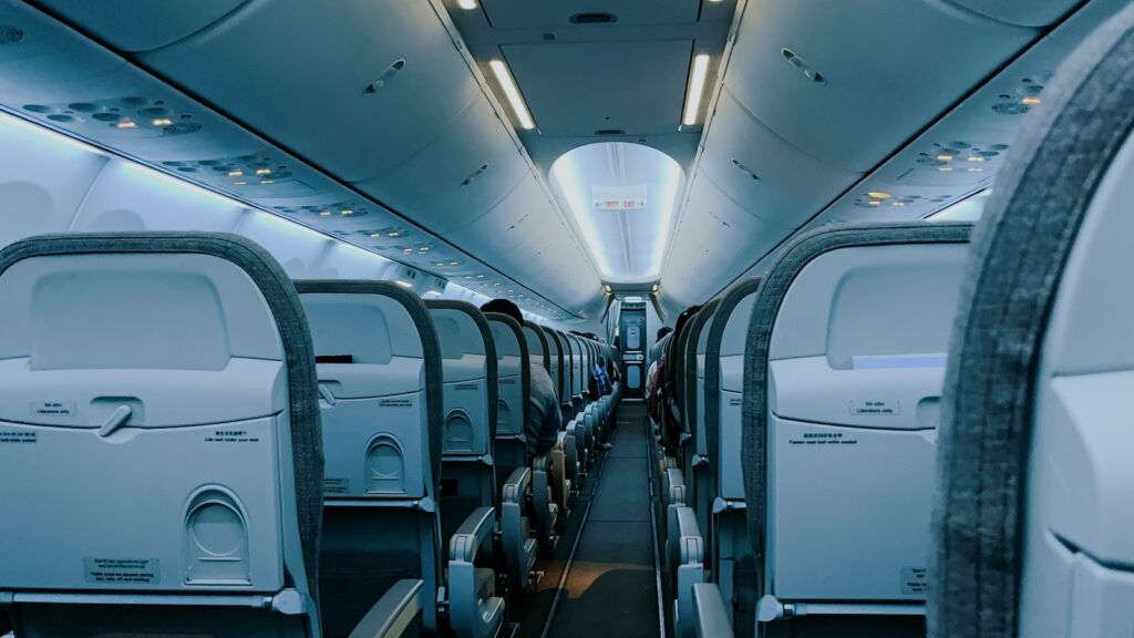 The inside of an airplane with rows of empty seats