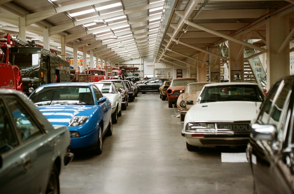 Row of classic cars displayed in a museum hall.