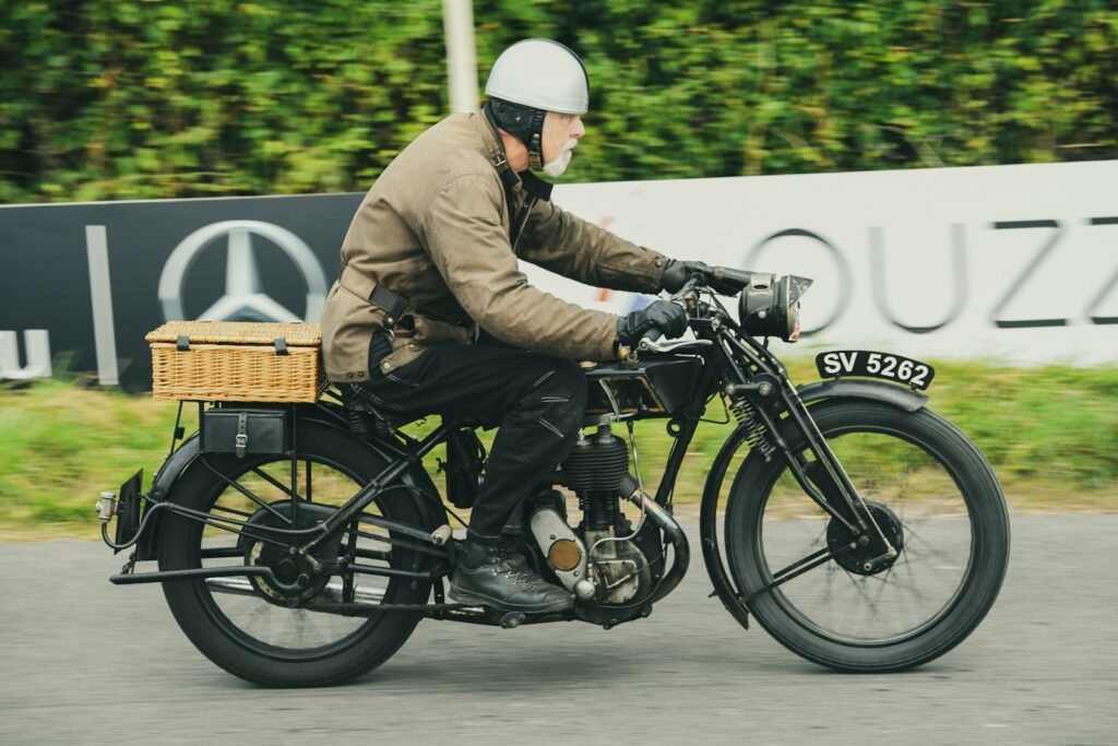Man riding vintage motorcycle with basket on back