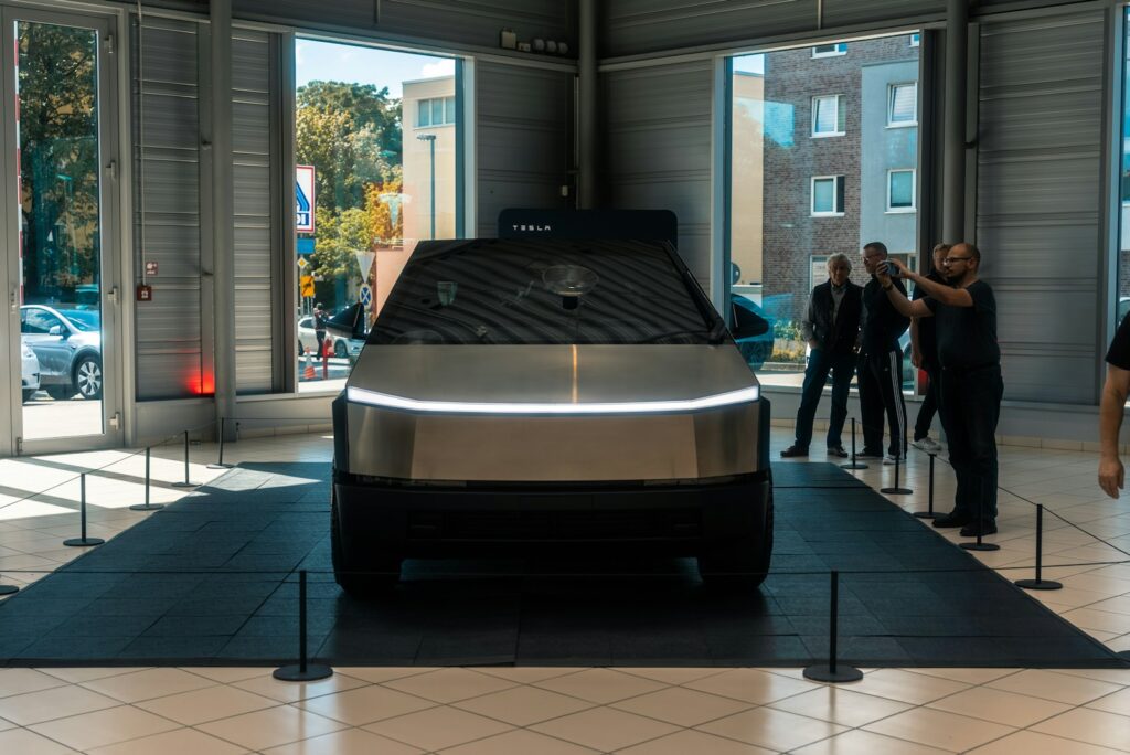 A group of people standing around a car in a showroom