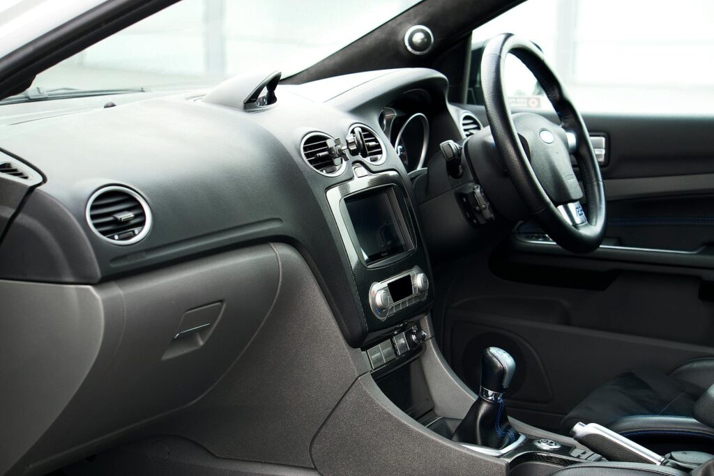 Detailed interior of a classic Ford car showcasing the dashboard and steering wheel in the United Kingdom.