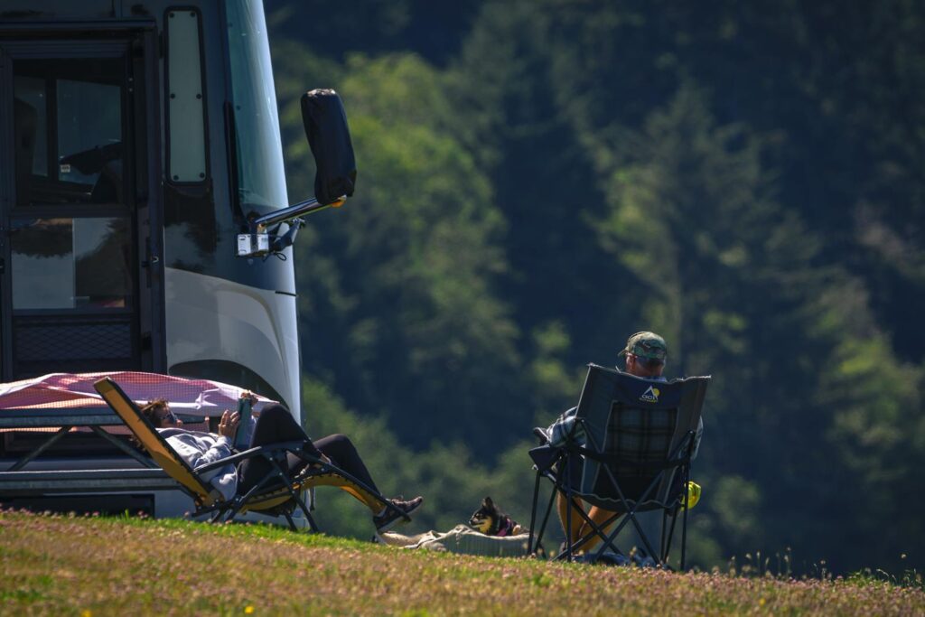 A couple enjoying a sunny day lounging by their RV in Reedsport, Oregon.