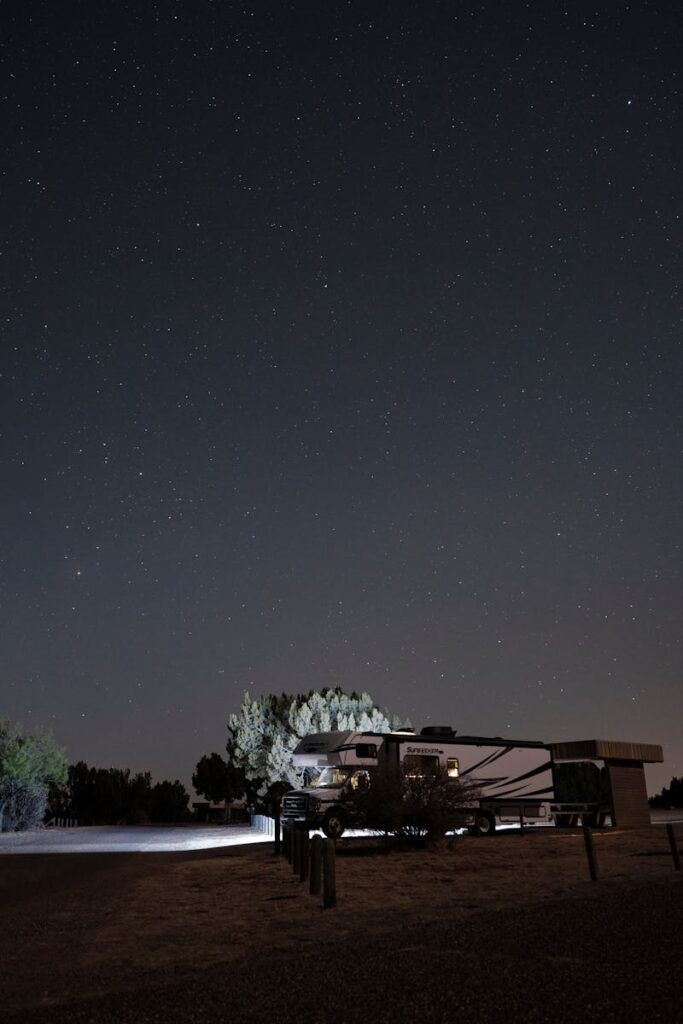 Tranquil night camping scene with RV under a starry sky in Newkirk, NM.