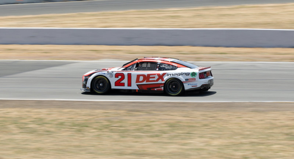 A racing car zooming on a track, showcasing speed and precision in motorsport.