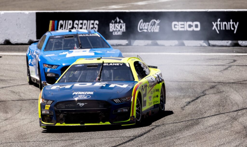 Nascar race cars speeding on a track, showcasing thrilling motorsport action.