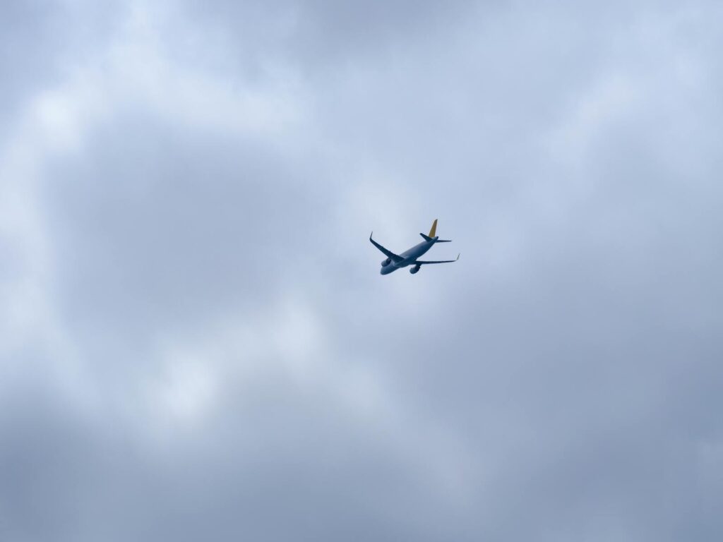 A modern aircraft flying high amidst thick cloud cover, showcasing aviation technology.
