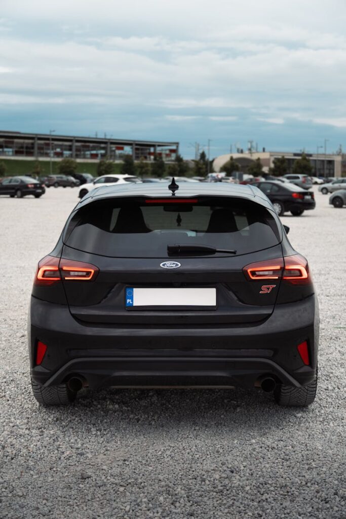 A sleek black hatchback car parked in an outdoor lot, showcasing modern design and detailing.