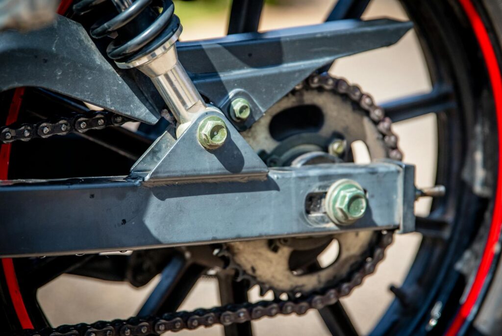 Detailed view of a motorcycle chain and wheel showcasing mechanical precision.