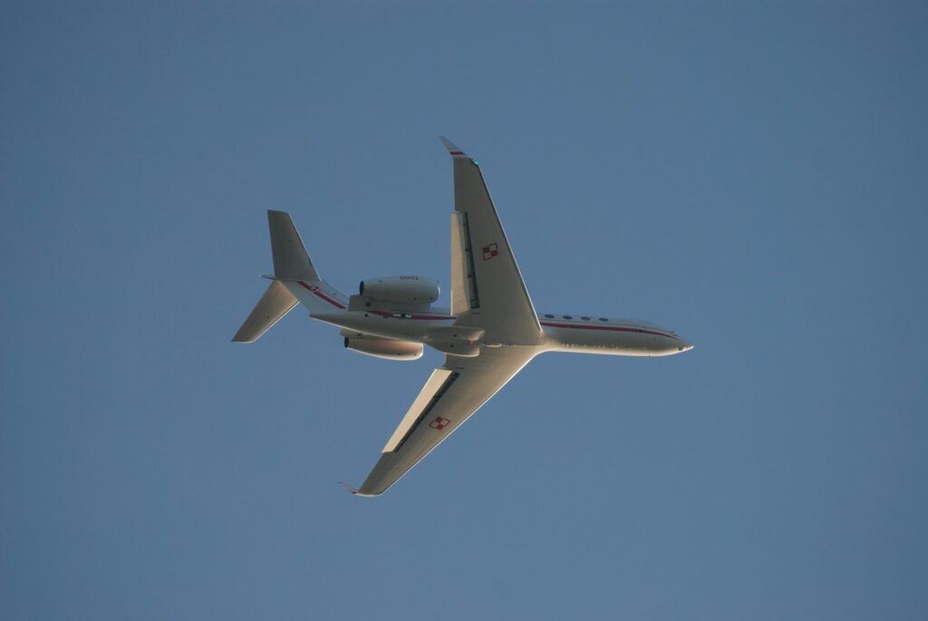 a plane flying in the sky with its landing gear down
