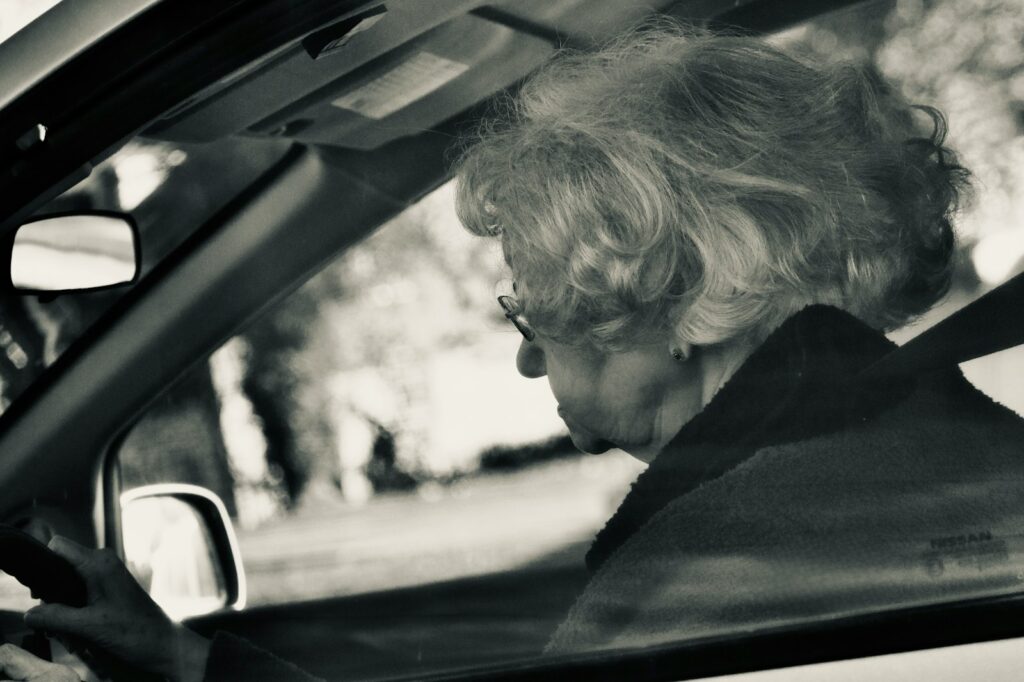 Elderly woman driving a car on a sunny day