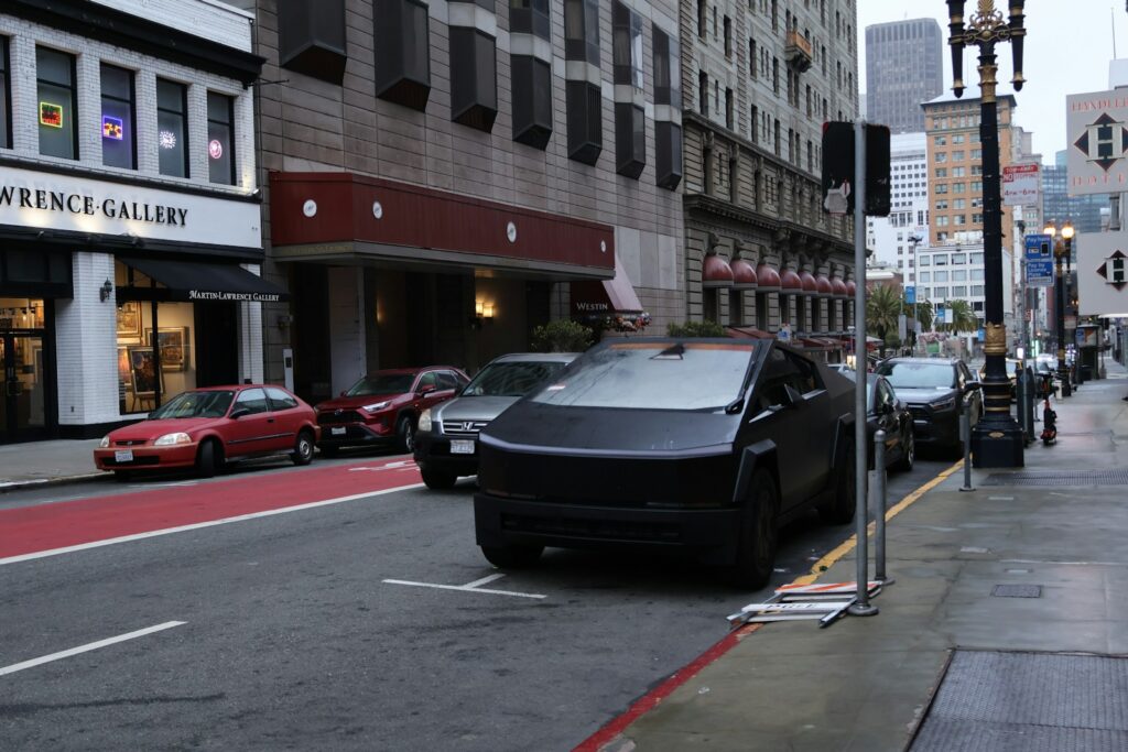 A black tesla cybertruck parked on a city street.