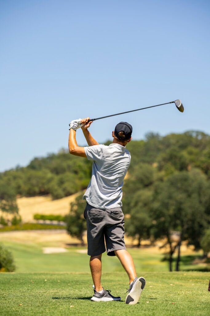 a man swinging a golf club on a golf course