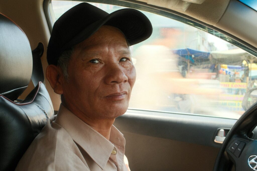 A man sits in the driver's seat of a car.