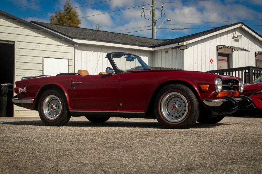 A classic red convertible car parked outside.