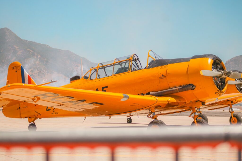 A small yellow airplane sitting on top of an airport tarmac