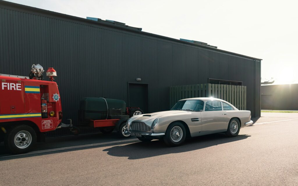 A classic car is parked next to a building.