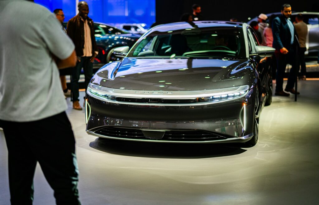 a group of people standing around a car on display