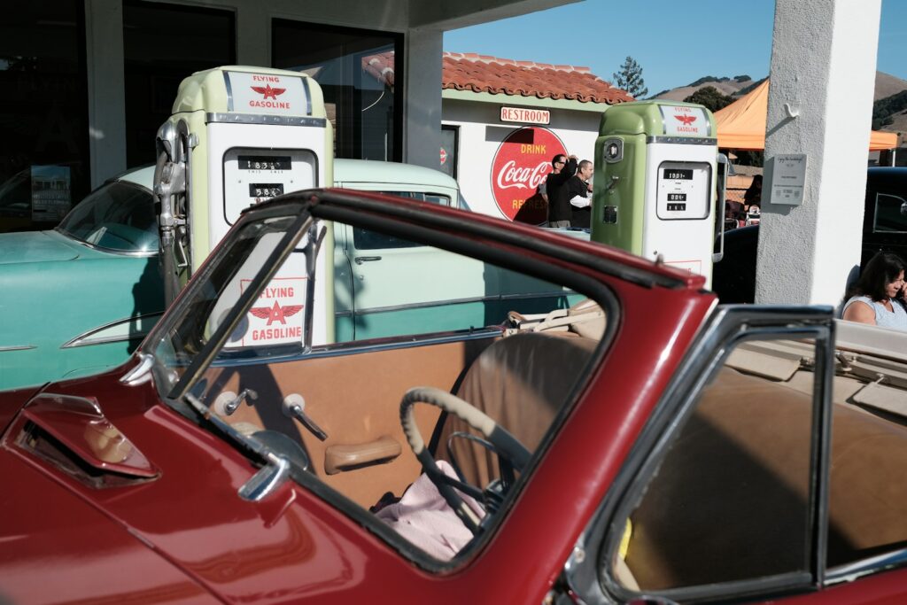 a red car parked in front of a gas station