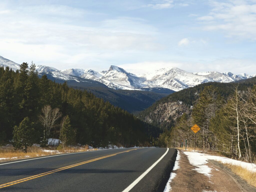 A scenic road leads to snow-capped mountains.