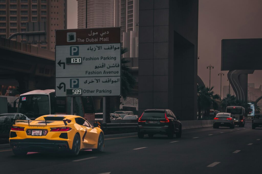 Yellow sports car driving on a city street.