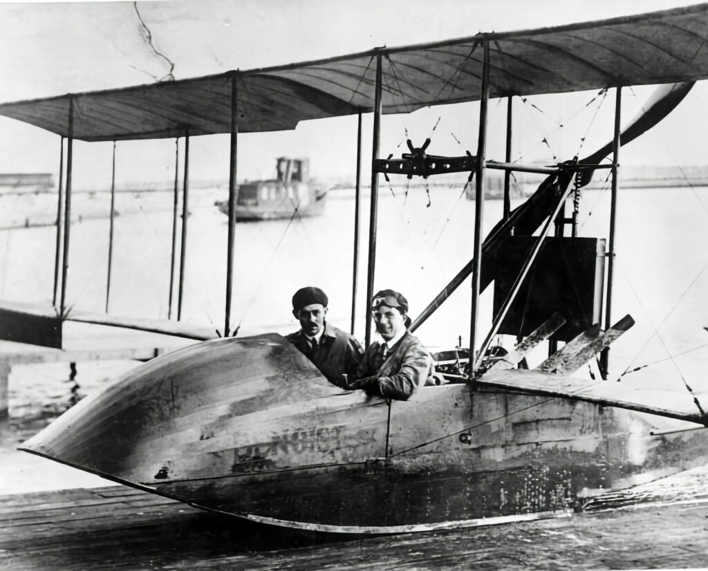 an old photo of two men in a biplane