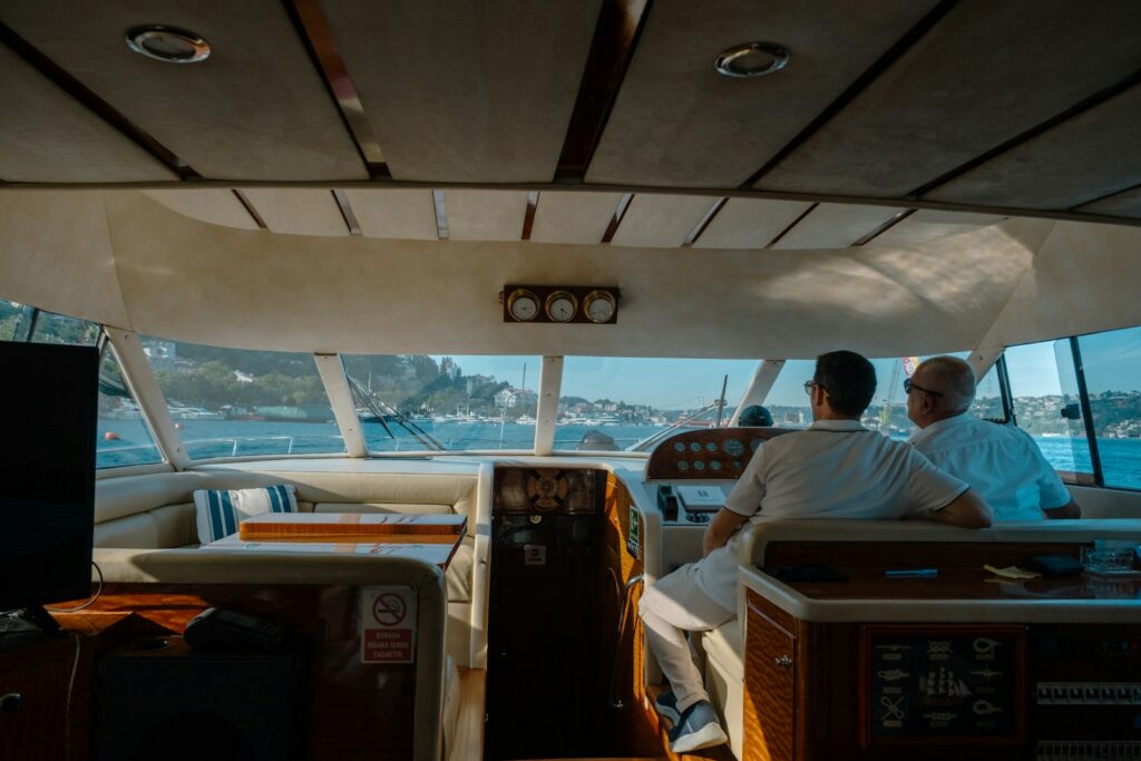 Two men in a yacht cockpit overlooking the sea