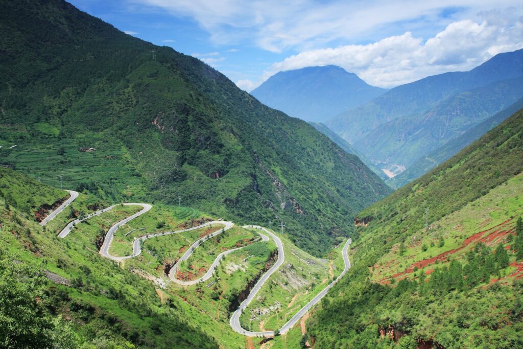 Winding mountain road through lush green valley