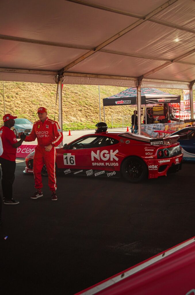 a group of people standing around a race car