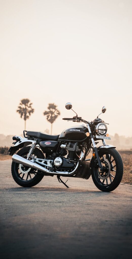 A Honda cruiser motorcycle parked at sunset with trees in the background.