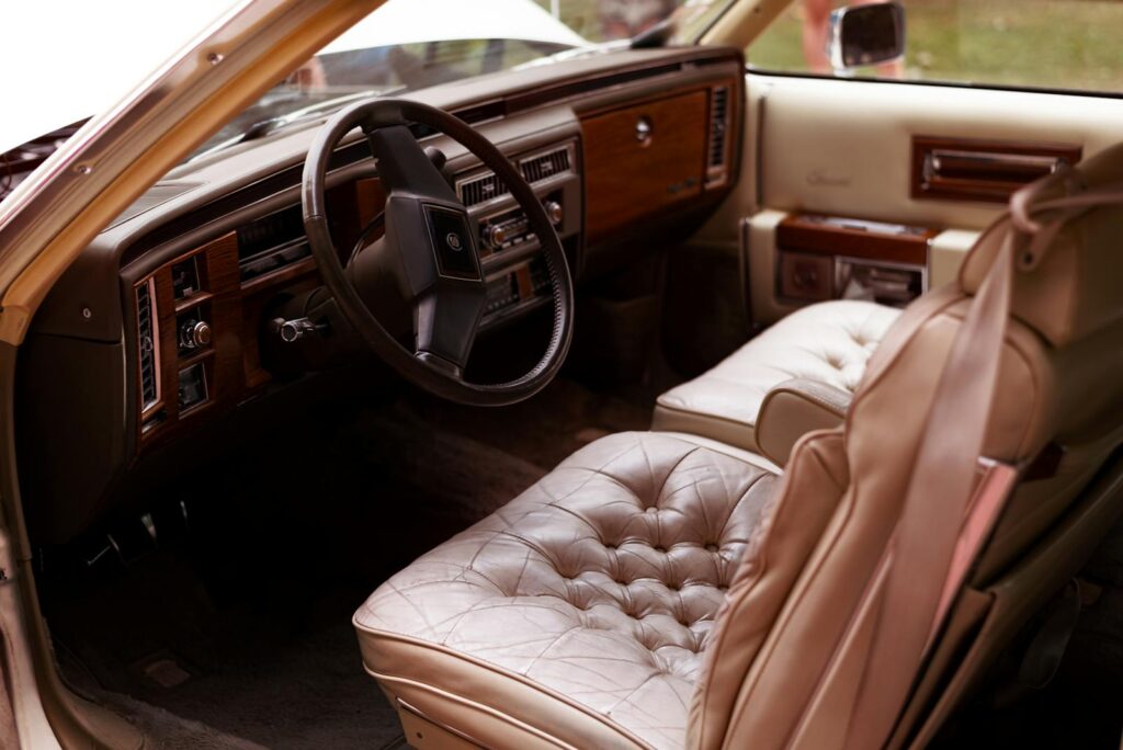 Explore the luxurious interior of a vintage Cadillac with leather seats and wood dashboard.