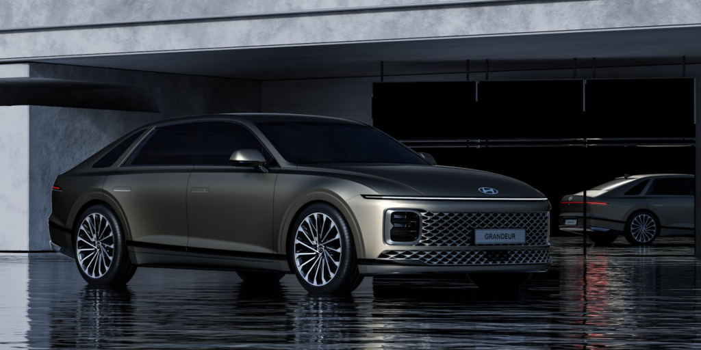 Sleek Hyundai Grandeur sedan with reflective surface and modern architecture.