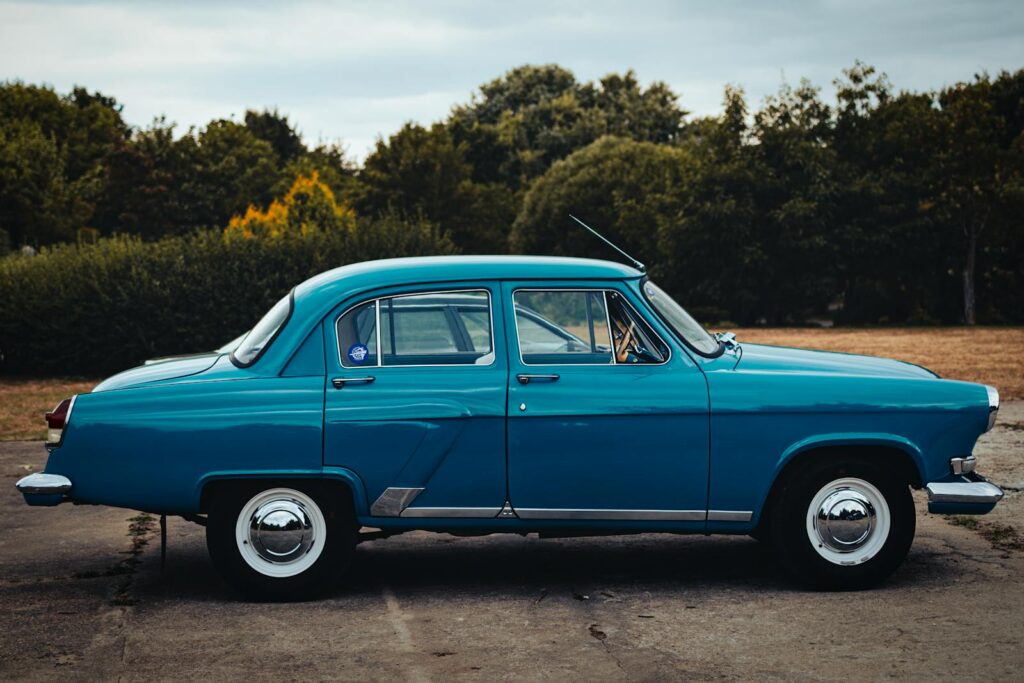 Classic blue Gaz 21 car parked outdoors in Minsk, Belarus during summer.