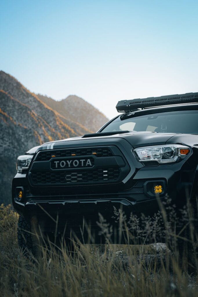 A robust black Toyota off-road vehicle poised in scenic mountain wilderness, showcasing rugged adventure.