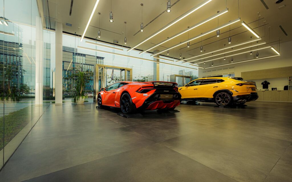 Showroom featuring luxury sports cars, Lamborghini models, with sleek design and modern architecture.