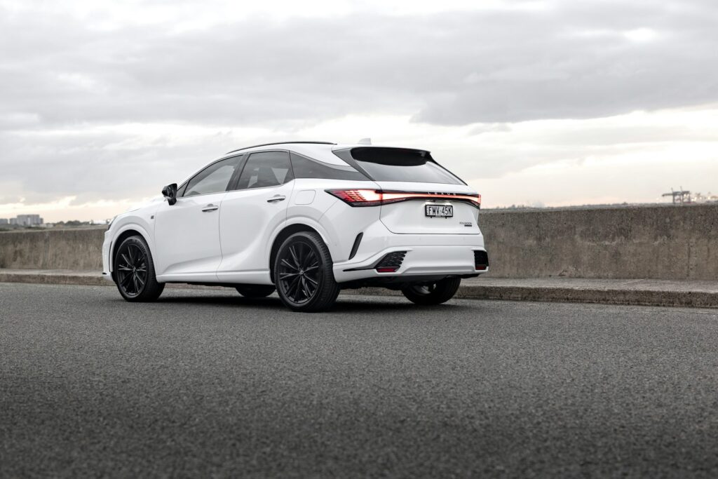 A white lexus suv is parked on the side of the road.